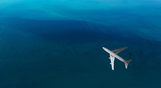 Aerial top view of Airplane flies over a sea, view from above