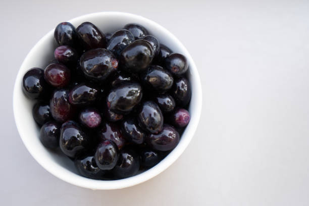istock Fresh black grapes and leaf on the white table. 1153241327