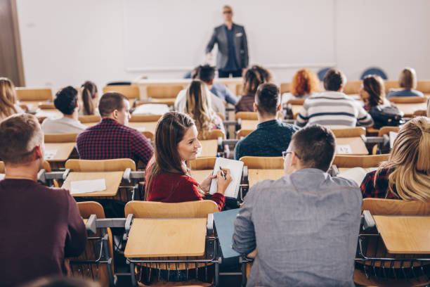 istock Young college students cooperating on a class at lecture hall. 1153241437