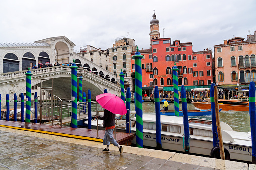 Tourists on a rainy day at the bridge named 'Ponte di Rialto' in the center of Venice, May 4, Italy 2018