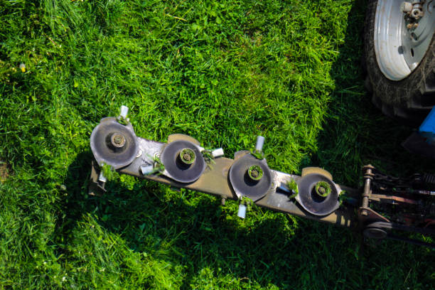 농업 작업 중 트랙터 용 디스크 깎는 기계를 장착, 빠른 회전 하는 동안 육즙 녹색 잔디 잔디 무자비. - rotary mower 뉴스 사진 이미지