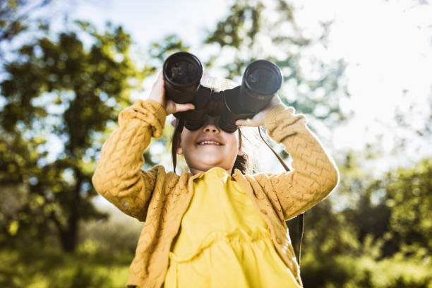 istock Happy little girl looking through binoculars in nature. 1153243595