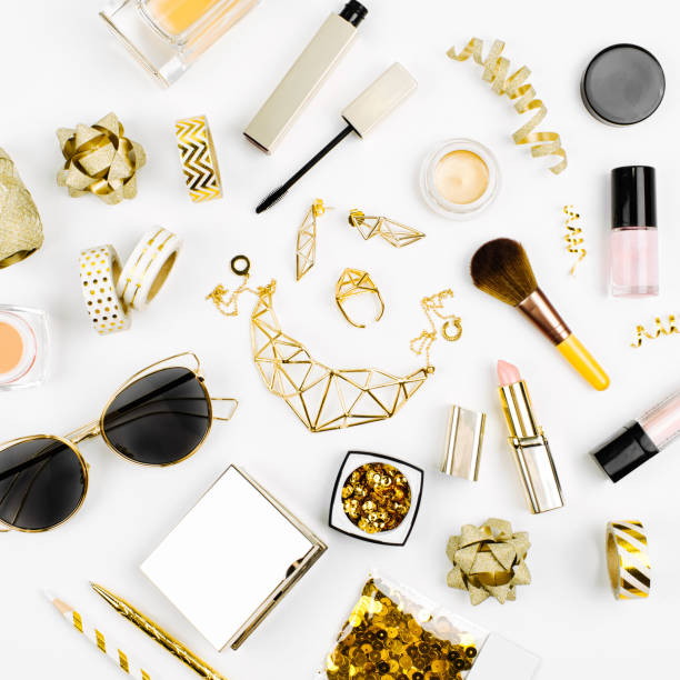 istock Cosmetics collage with lipstick, brush and other accessories on white background. Composition in gold colors. Flat lay, top view. 1153243811
