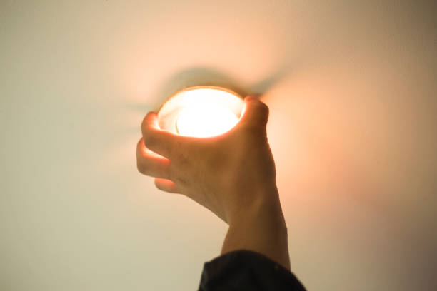 istock installation of point light, hand inserts the lamp into the ceiling 1153243994