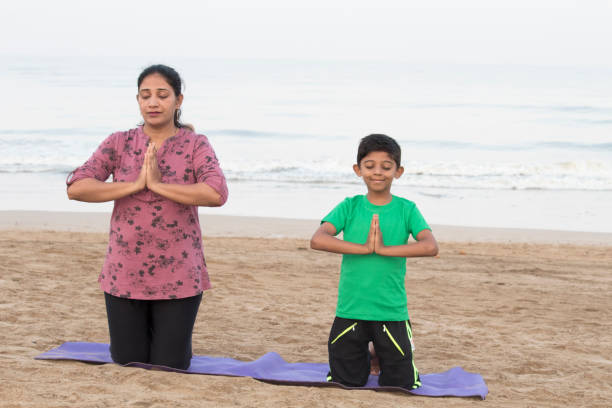 istock Mother and son doing yoga at beach 1153244859