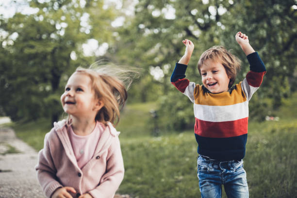 istock Happy little kids having fun in spring day at the park. 1153246106