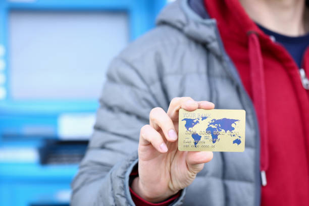 istock Male hand hold bank plastic card aganist atm 1153249202