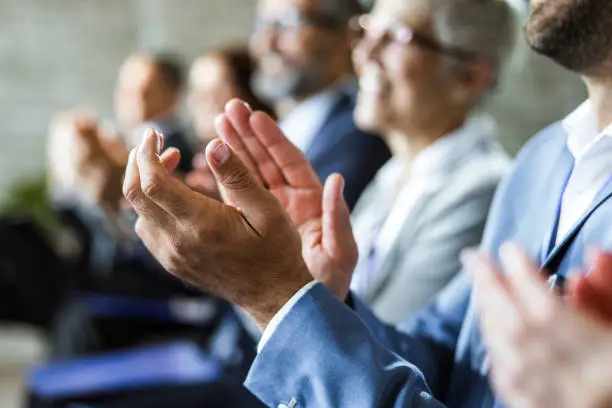 Close up of unrecognizable businessman clapping his hands on a seminar in board room.