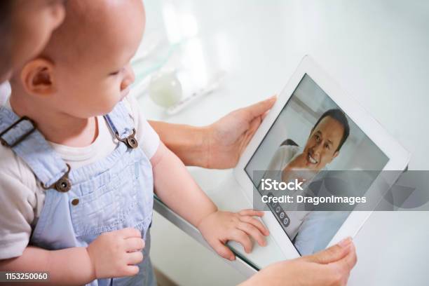 Donna Con Baby Videochia Chiamata Marito - Fotografie stock e altre immagini di Telemedicina - Telemedicina, Bambino, Pediatra