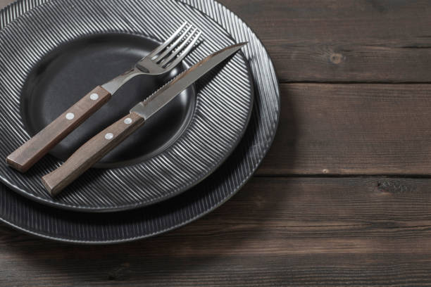 istock black plates on wooden background 1153254478