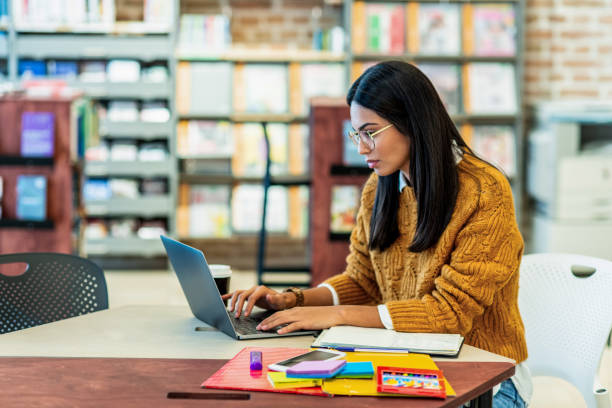istock young woman working on her laptop in the library 1153255087