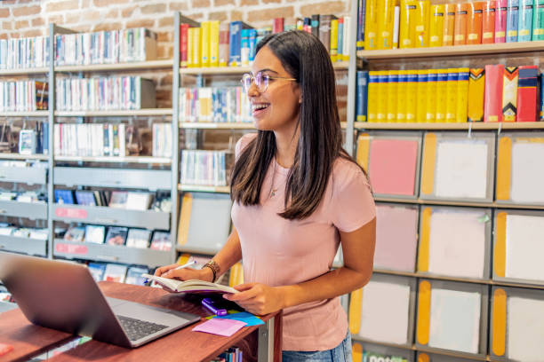 istock young woman working on her laptop in the library 1153256391