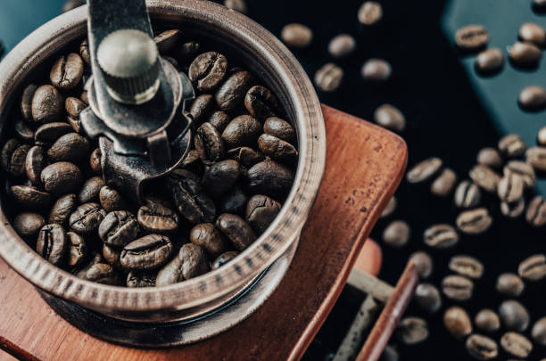 istock Coffee grinder with coffee beans on the reflective surface. Making coffee. 1153260785