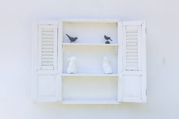 front view of wooden small cupboard with white rabbit and black bird statue.