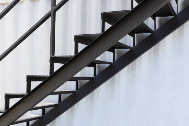 outside metal staircase or fire exit stair with sheet corrugated wall background. stock photo