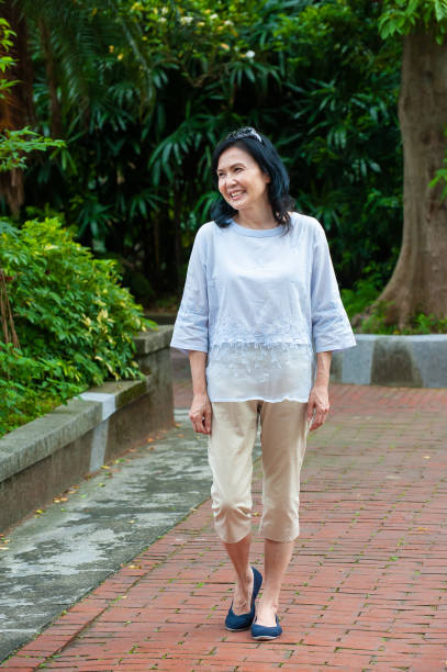 istock Senior woman taking leisure walk in park 1153261919