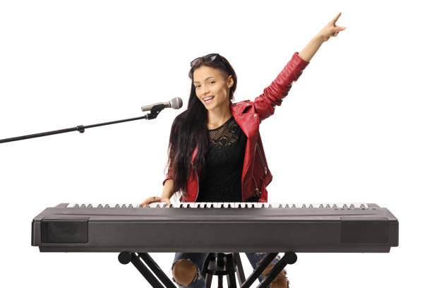 istock Smiling young woman playing a keyboard and singing on a microphone 1153261989