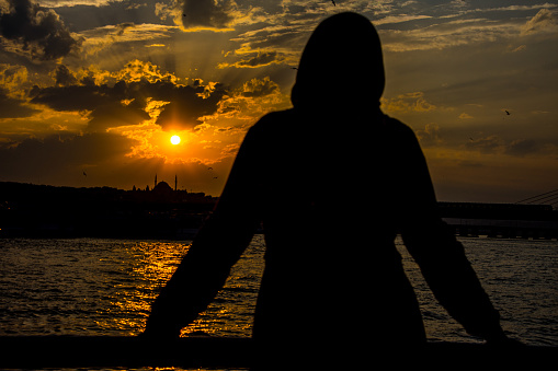 The muslim girl with hijab looking the beautiful sunset  above the city of Istanbul in Turkey