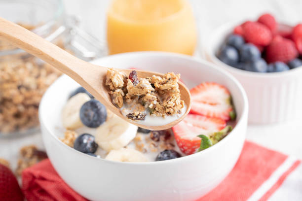 istock granola and milk in wooden spoon 1153266496