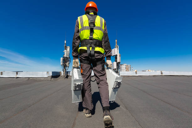 Telecommunication engineer in helmet and uniform holds telecomunication equipment in his hand and antennas of GSM DCS UMTS LTE bands, outdoor radio units, optic fibers, power cables are installed on the roof. Working process of upgrading telecommunication equipment ingeniero de telecomunicación en casco y uniforme sostiene equipos de telecomunicación en su mano y antenas de gsm dcs umts lte bandas, unidades de radio al aire libre, fibras ópticas, cables de alimentación se instalan en el techo. proceso de moderniz