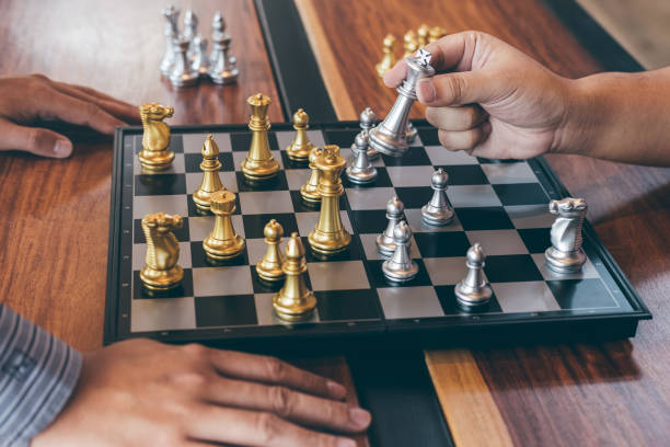 istock Intelligent businessman playing chess game competition with the opposite team, planning business strategic to development for win and success, Gold and silver chess with player 1153267945
