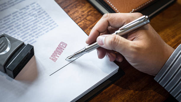 Close up hands of businessman signing and stamp on paper document to approve business investment contract agreement Close up hands of businessman signing and stamp on paper document to approve business investment contract agreement. business loan stock pictures, royalty-free photos & images