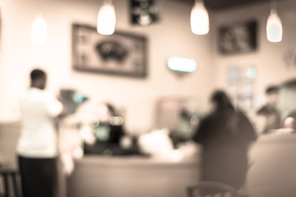 Vintage tone blurred interior of a Vietnamese Noodle (Pho) restaurant in Humble, Texas, US. Classic tables, chairs for dining, customers queuing in front of counter to checkout/order takeout food