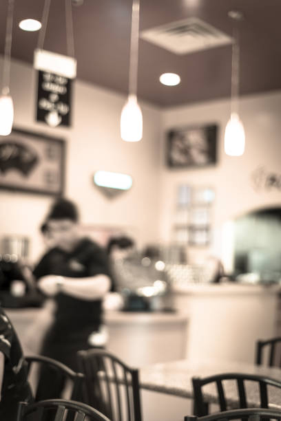 Vintage tone blurred checkout counter at a Vietnamese Noodle (Pho) restaurant in Humble, Texas, US. Cashier is working behind the pay terminal/computer and waiters are on duty serving food