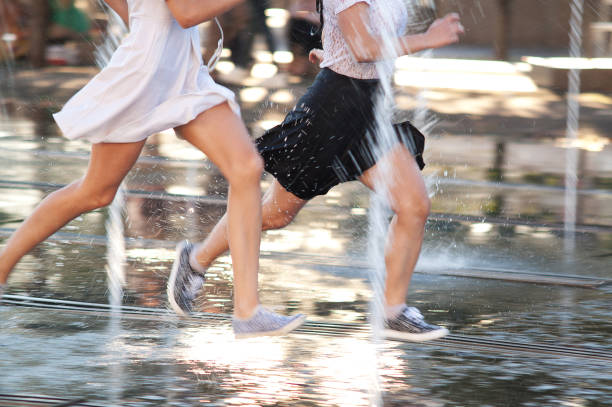 Asian girl trying to splash her friend, while carrying shopping bags in her hands.
