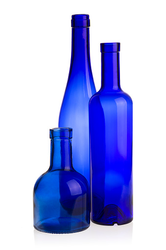 Three blue glass bottles of different shapes