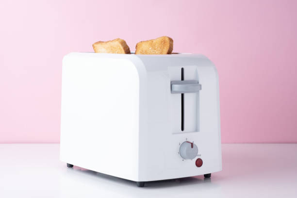 istock White toaster with  roasted toast bread on pink background, close up 1153277419