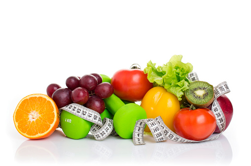 fitness equipment and healthy food isolated on white. apple, pepper, grapes, kiwi, orange, dumbbells and measuring tape