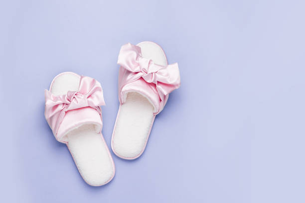 istock Stylid female slippers with bow on pale blue  background. Flat lay, top view 1153281616