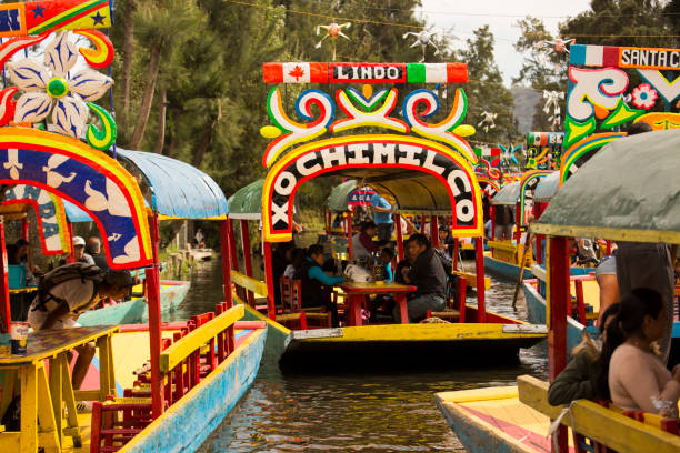 Xochimilco Boats Xochimilco, Federal District /Mexico - December 28, 2018: Traditional trajineras, or boats, float through the Canal Ampampilco in Xochimilco. trajinera stock pictures, royalty-free photos & images