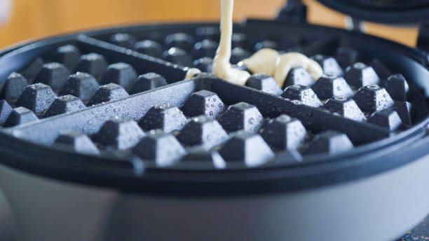 istock Making homemade waffles in an electric waffle maker. 1153286779