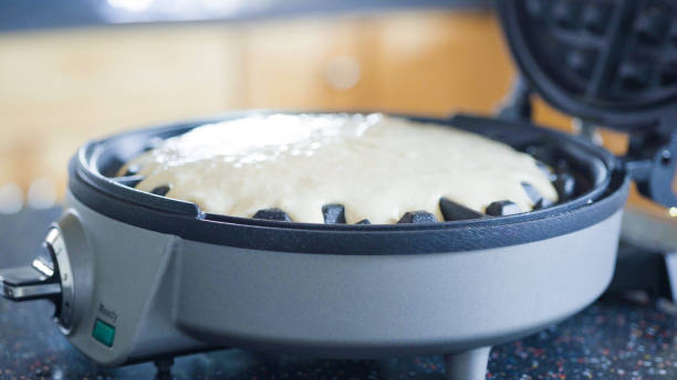 istock Making homemade waffles in an electric waffle maker. 1153286796