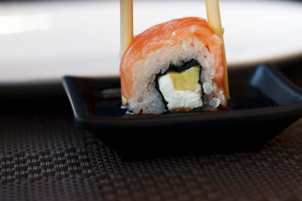 istock Sushi dunk in soy sauce, close-up 1153291364