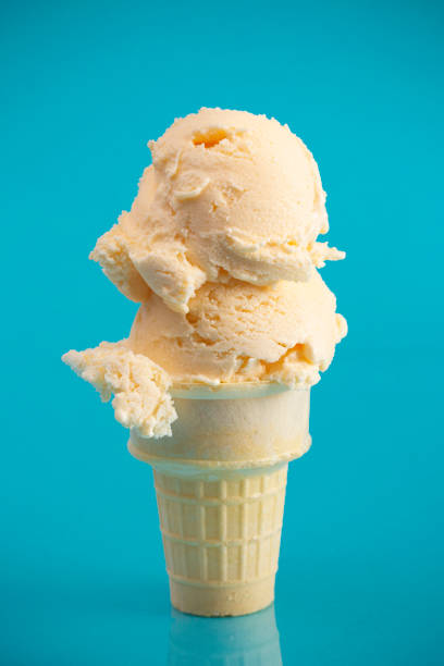 istock Double Scoop Vanilla Ice Cream Cone on a Blue Background 1153292938