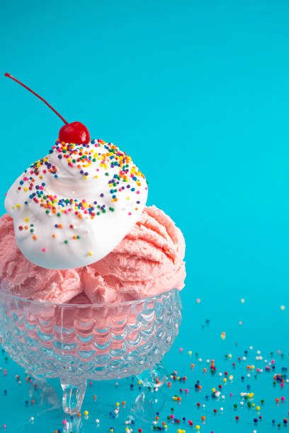 istock A Strawberry Ice Cream Sundae on a Bright Blue Background with a Cherry on Top 1153292947