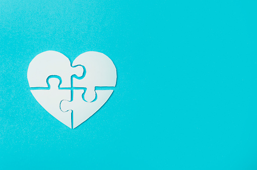 White heart made of symbolic autism puzzle pieces