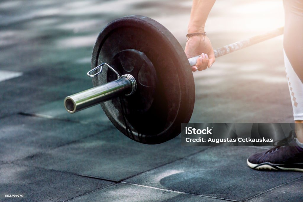 gym woman preparing for her weightlifting workout with a heavy dumbbell Achievement Stock Photo