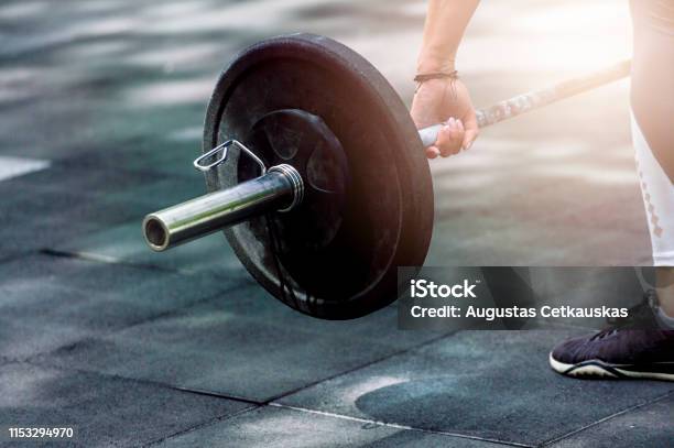 Gym Woman Preparing For Her Weightlifting Workout With A Heavy Dumbbell Stock Photo - Download Image Now