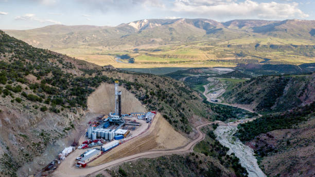 晩春のコロラドの山の側面にあるフラッキングドリルリグの空中図 - borehole ストックフォトと画像