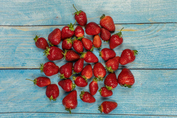 fresas en el fondo de madera azul. lugar para su logotipo o texto - zumo 660 fotografías e imágenes de stock