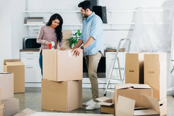 istock cheerful latin couple packing boxes while moving to new home 1153300255