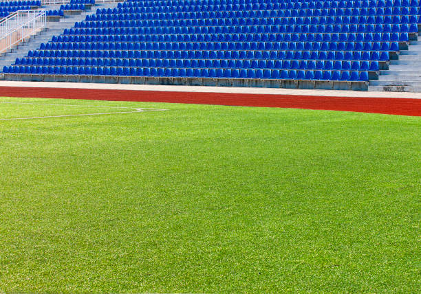 istock The empy green field and blue seats at the stadium 1153301898