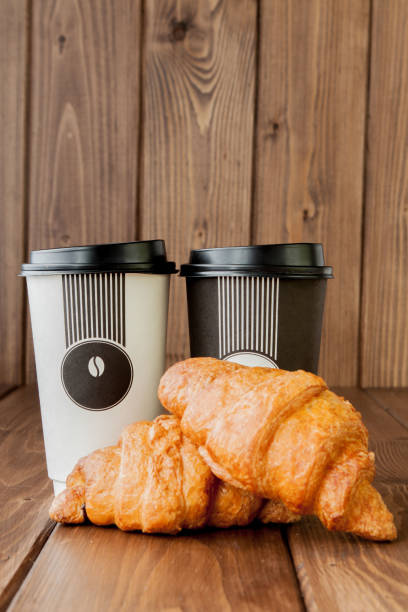 istock Paper coffee cup and croissants on wooden background, Copy space 1153302992