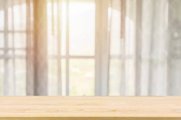 istock Empty wood table top with window curtain abstract blur background for product display 1153306877