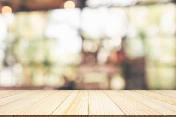 istock Empty wooden table top with cafe restaurant or coffee shop window interior abstract blur defocused with bokeh light background for montage product display 1153307512