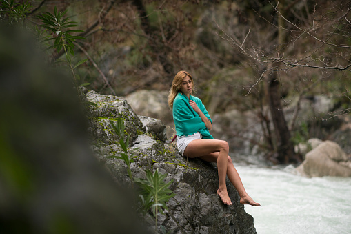 Beautiful Woman sitting on a rock near the river, Antalya, Turkey